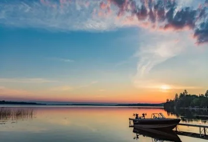 Quiet peaceful fishing boat at the dock at the cottage on the lake